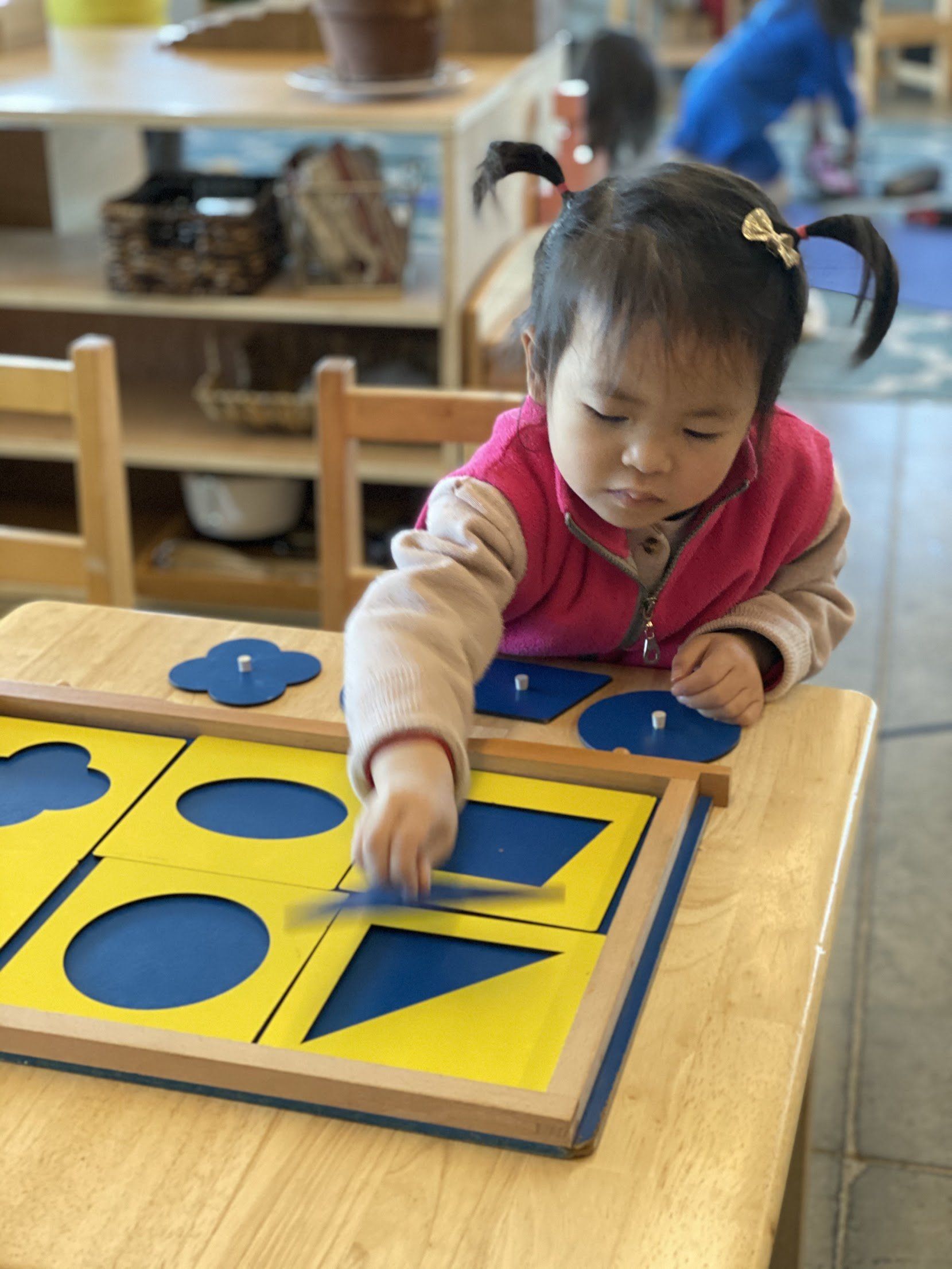 A kid playing with geometrical shapes