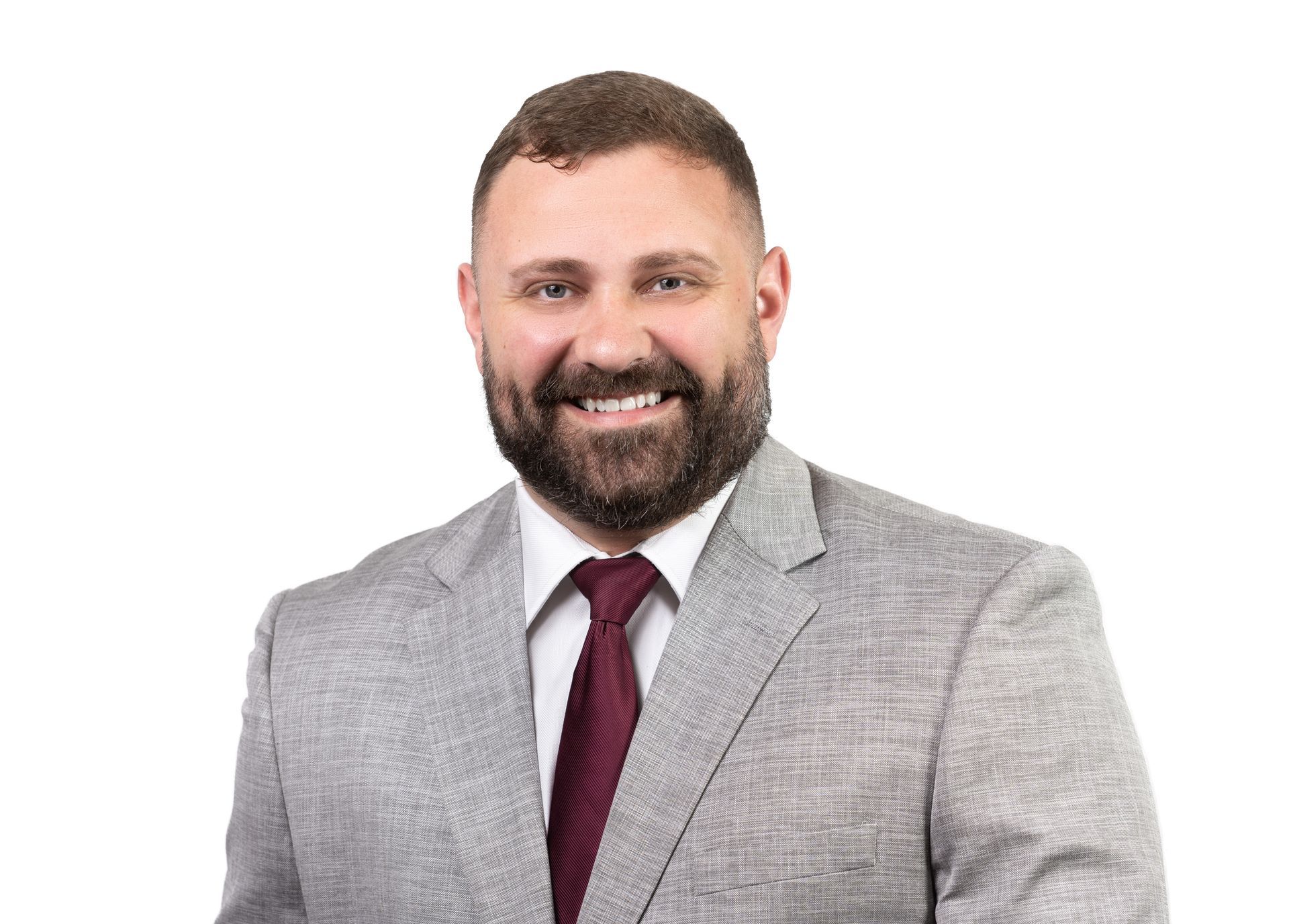 A man with a beard is wearing a suit and tie.