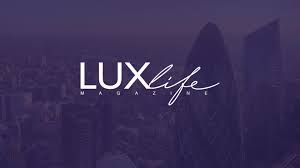 The LUXlife Magazine logo in white text centered over a blurred, dark purple cityscape.