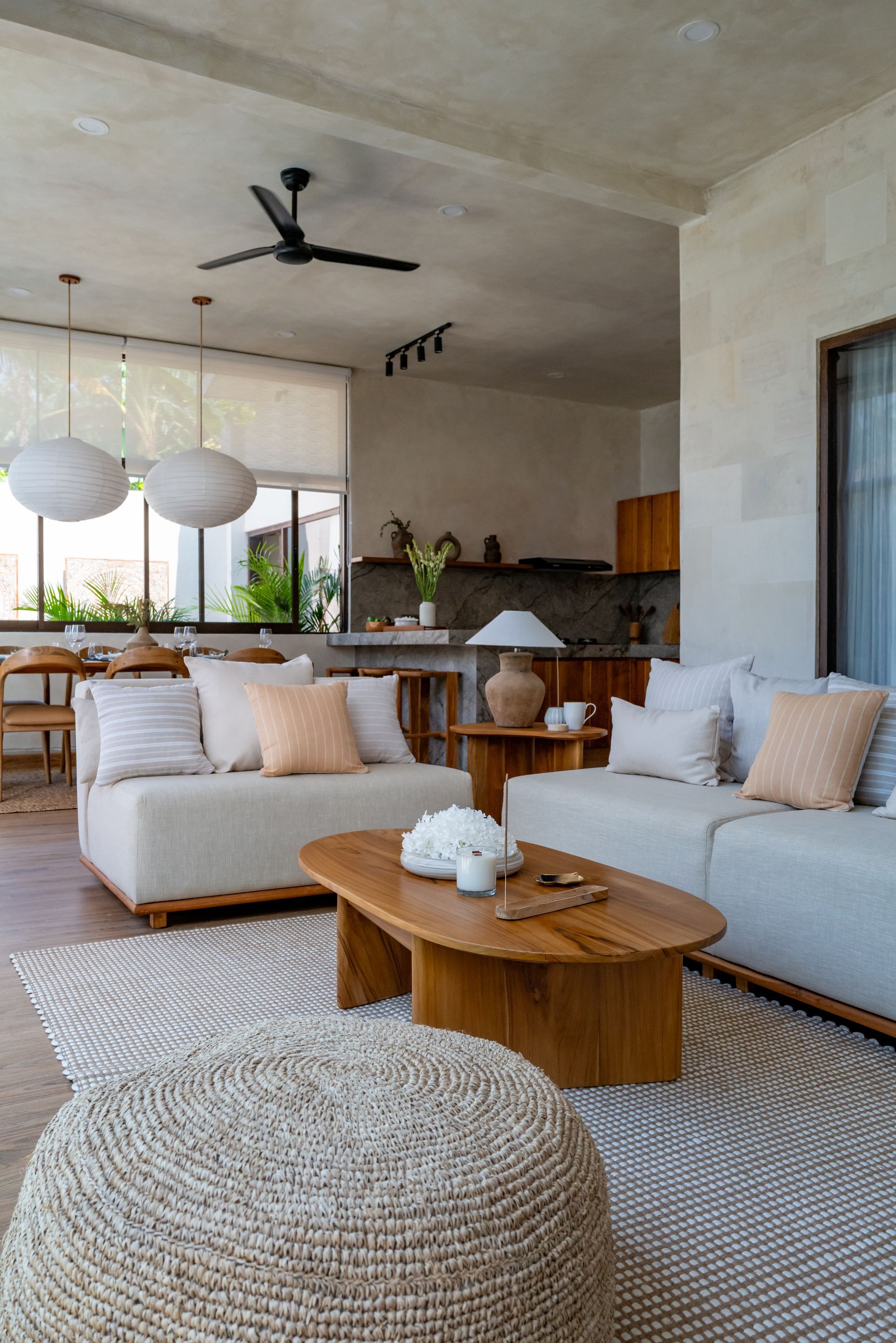 Cozy living room with neutral colors, two sofas, a wooden coffee table, and a woven rug.