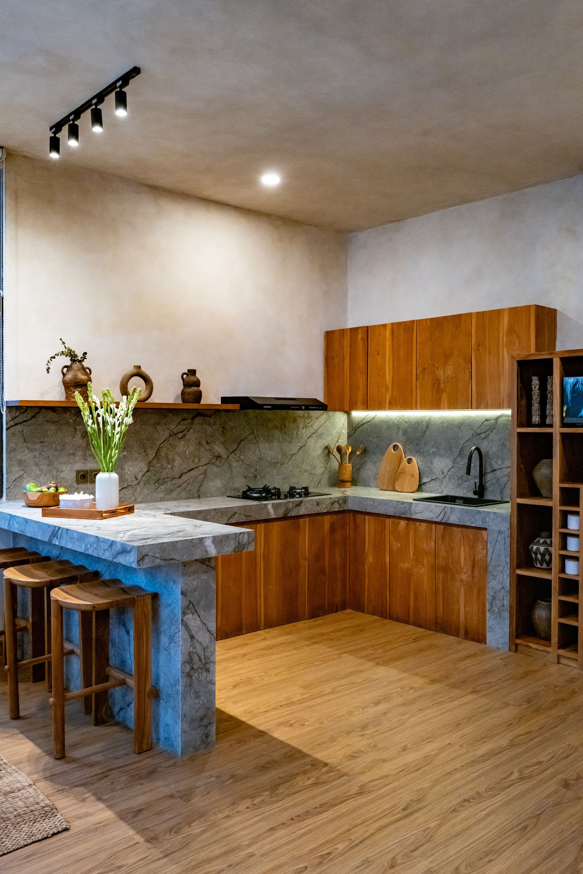Modern kitchen with wood cabinets, concrete countertops, and a breakfast bar.