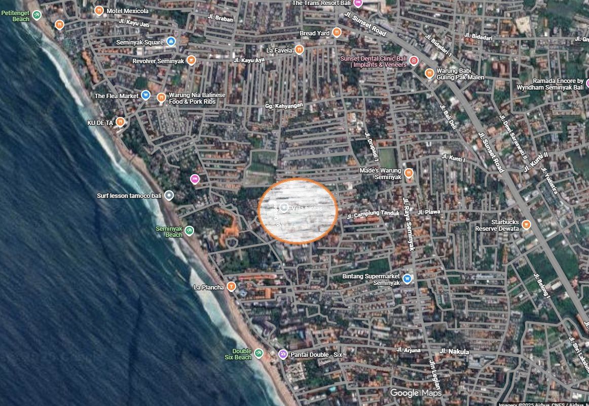 Aerial view of Seminyak, Bali, ocean on left. Central area highlighted by a light-colored circle.