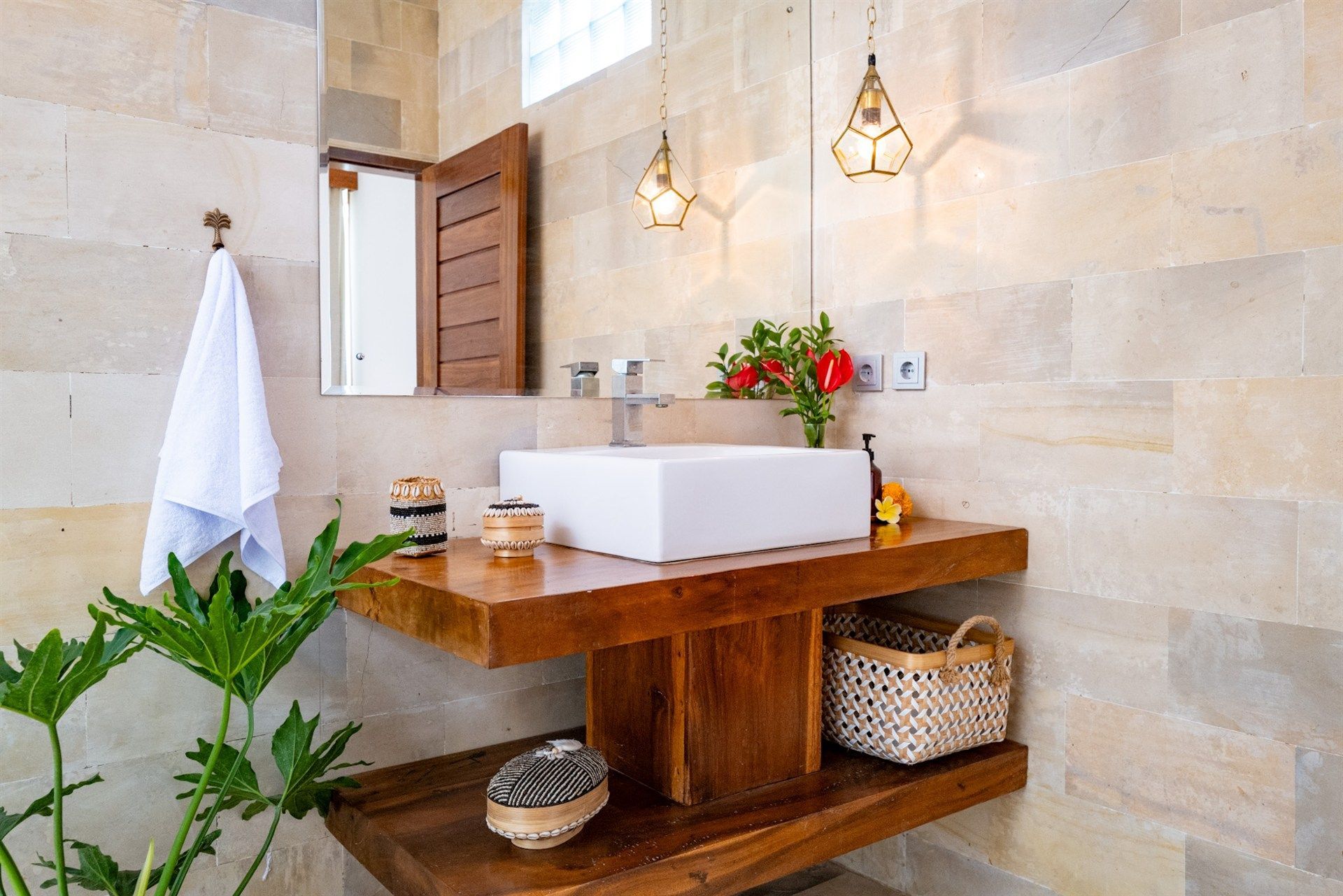 Bathroom with a square white sink on a wooden counter, decorative lighting, and a wicker basket.