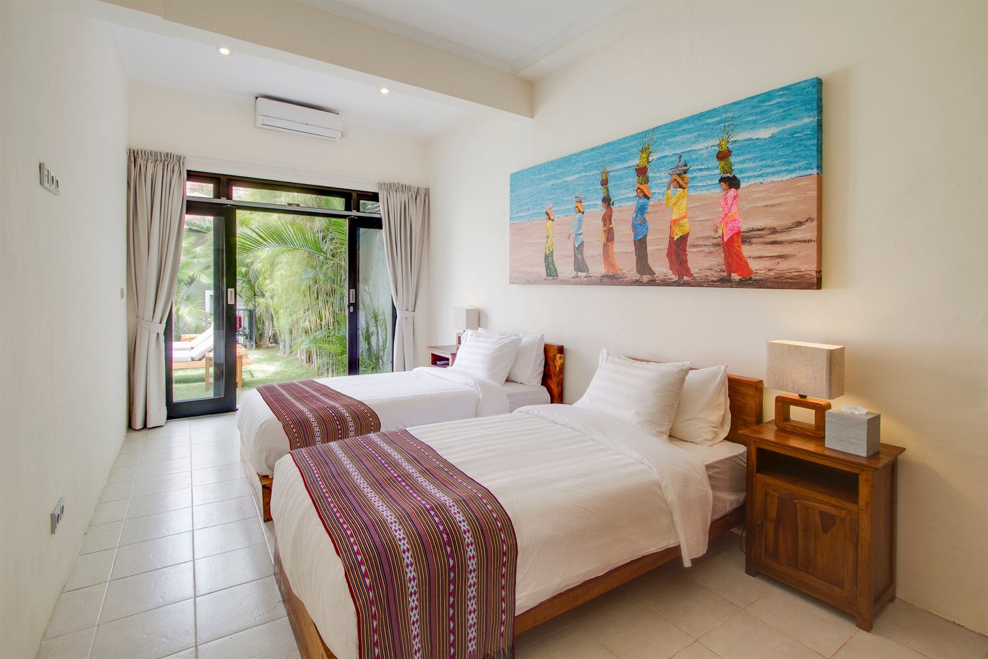 A hotel room with two beds and a painting on the wall.