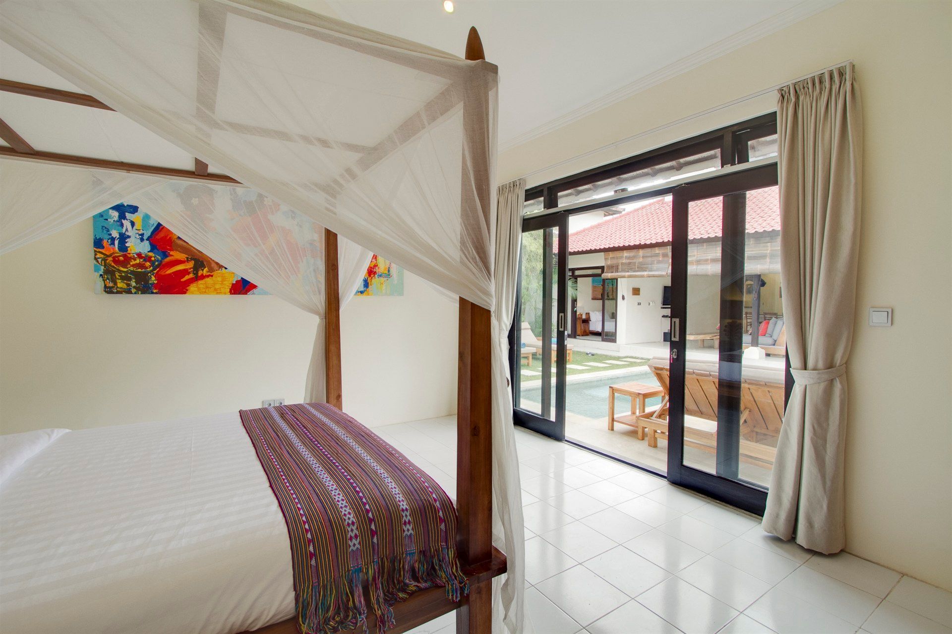 A bedroom with a canopy bed and sliding glass doors