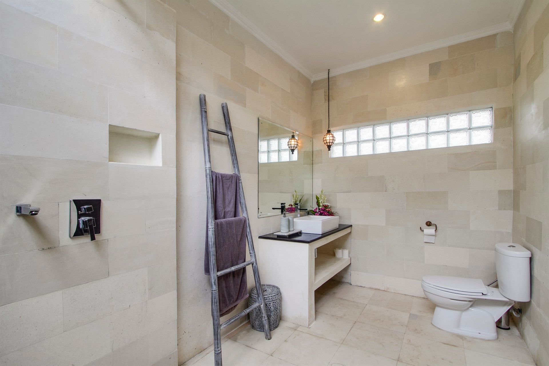 A bathroom with a toilet , sink and mirror.