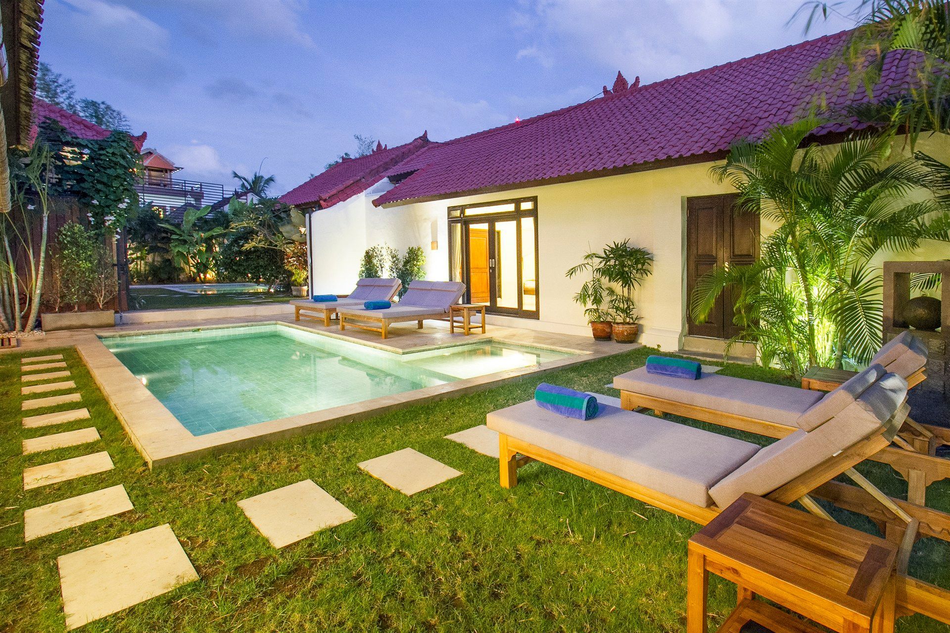 There is a large swimming pool in the backyard of a house.