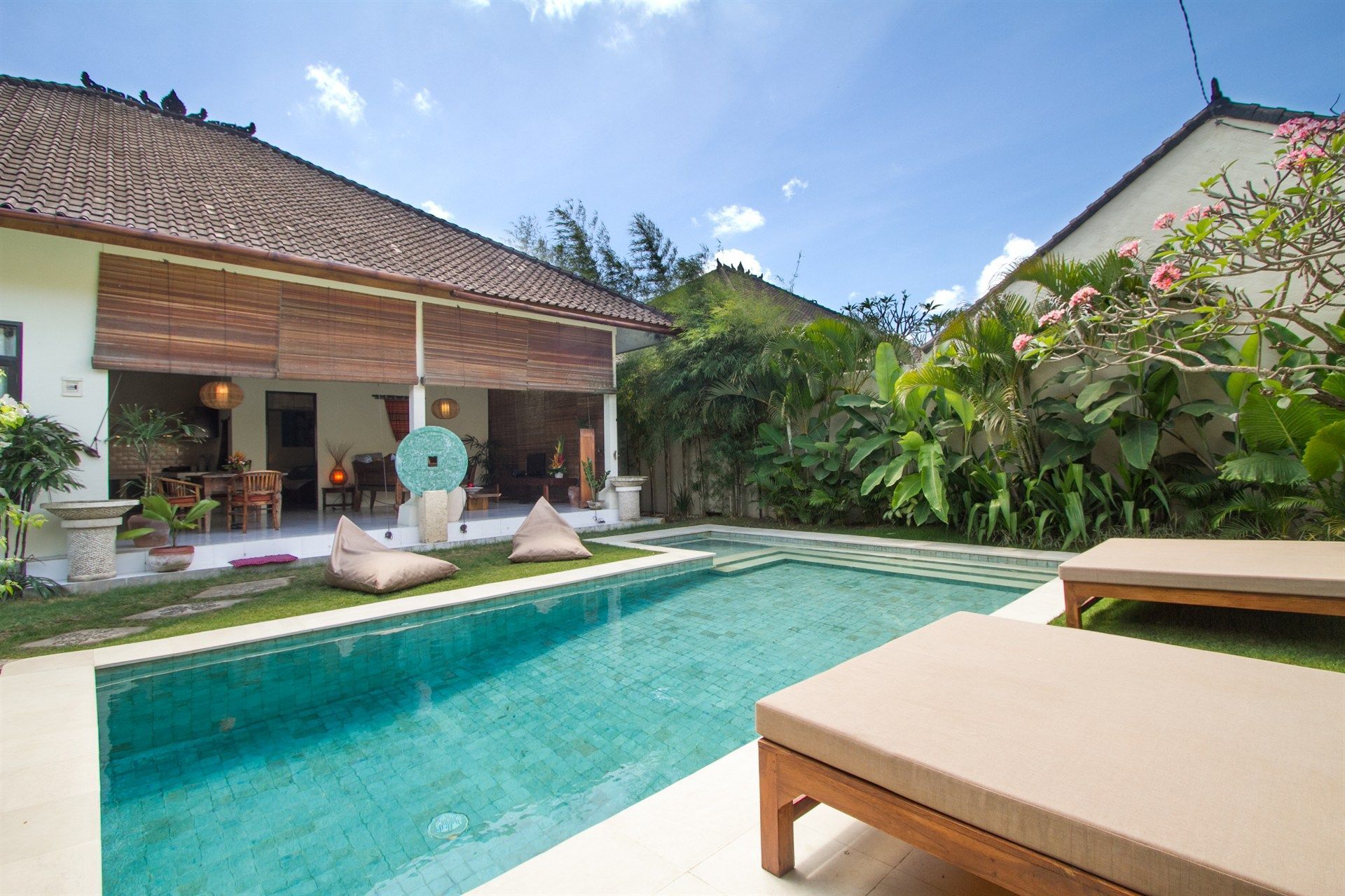 There is a large swimming pool in the backyard of a house.