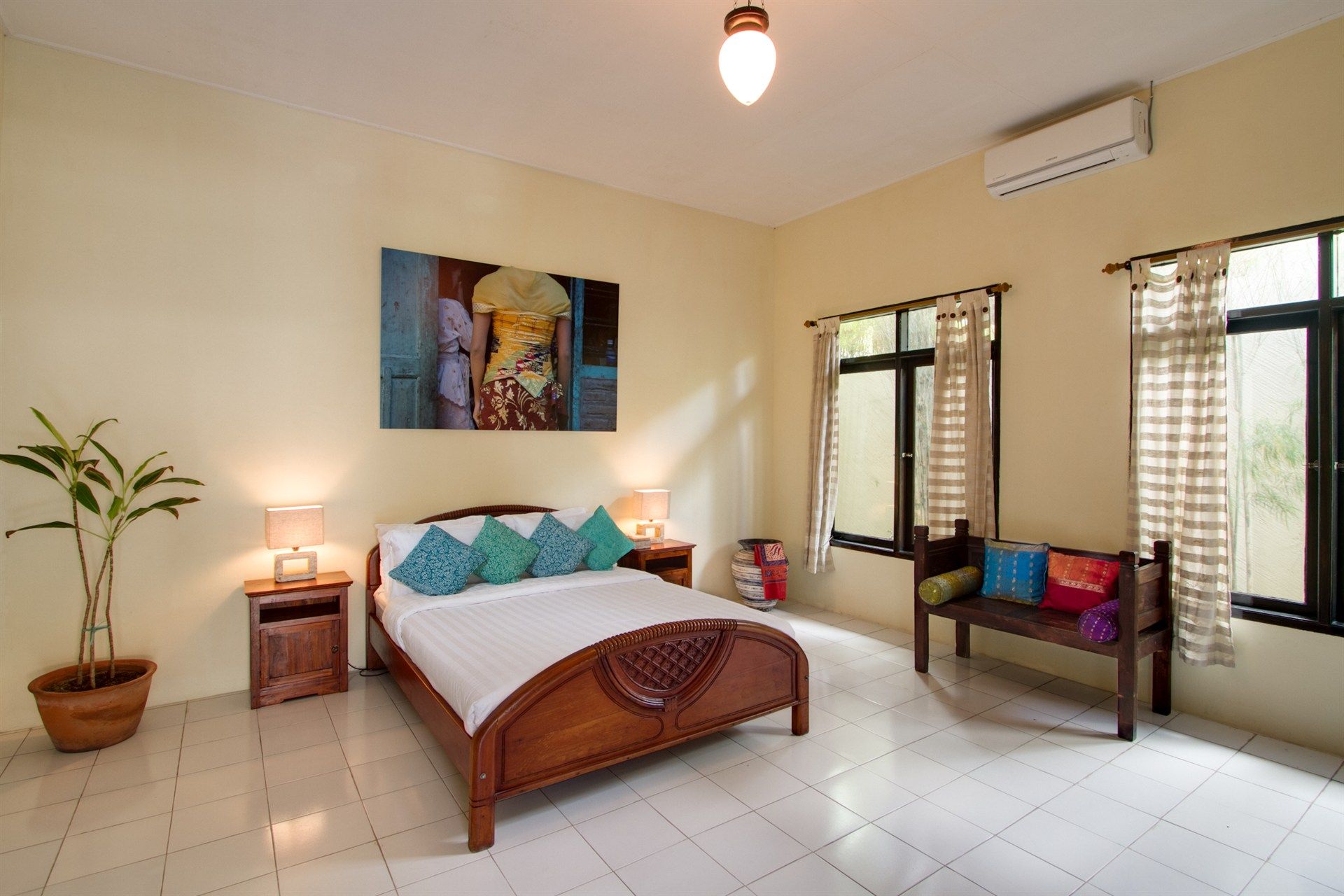 A bedroom with a large bed and a bench