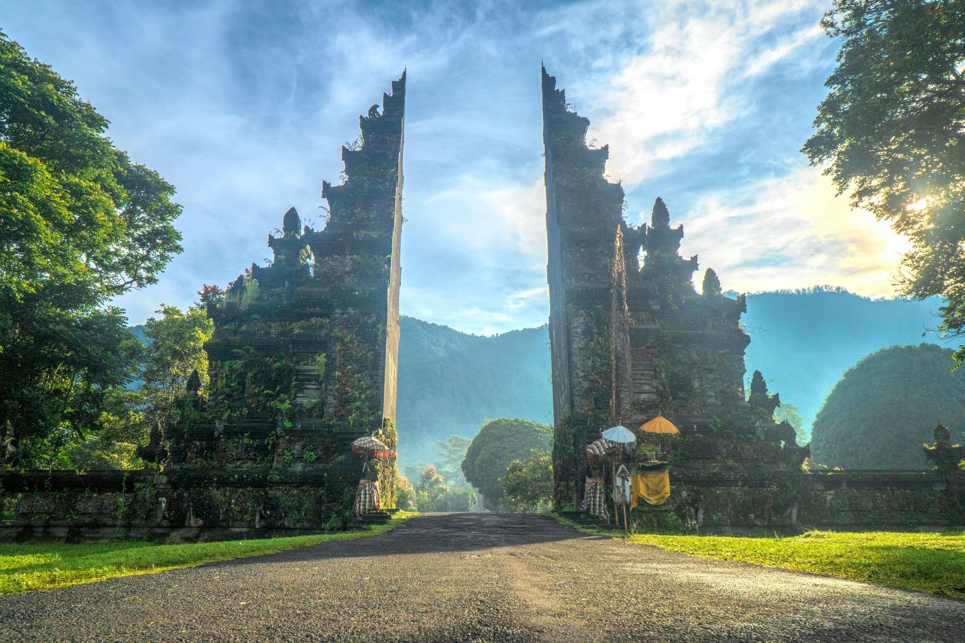 A group of people are standing in front of a large stone archway.