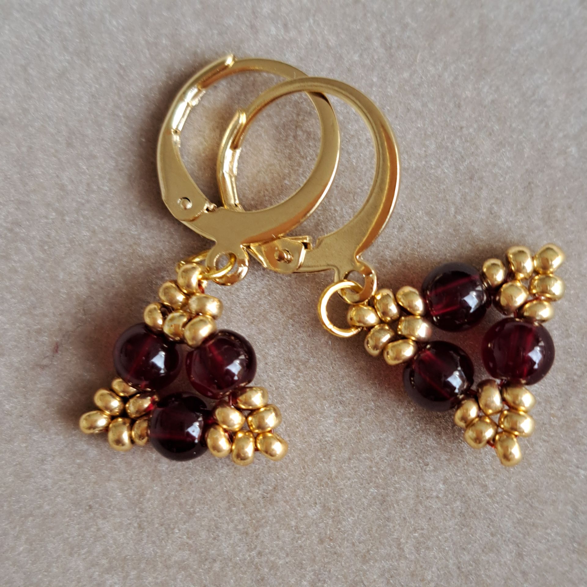 173, Oorbellen donker rood met goud