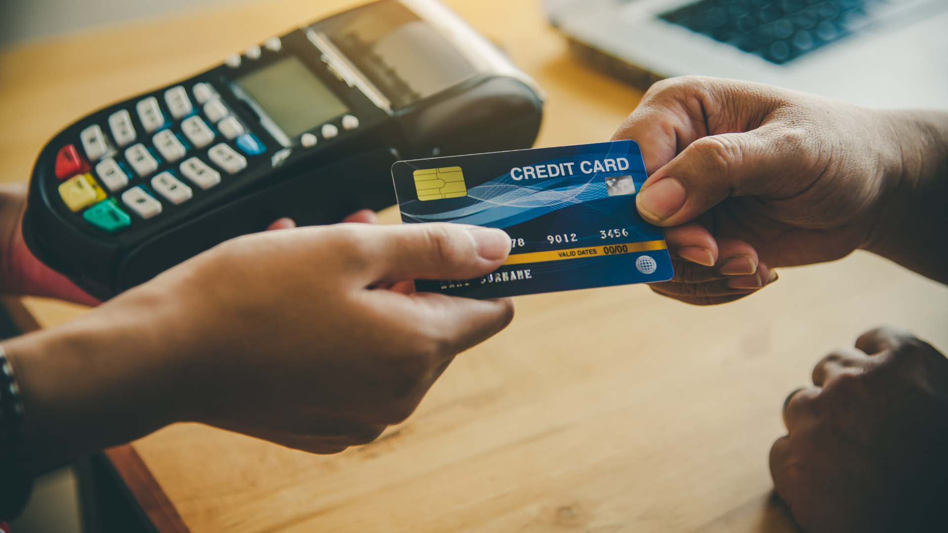 A person is handing a credit card to another person.