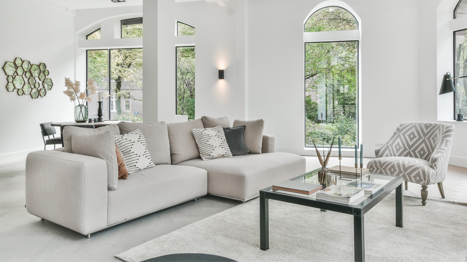 A living room with a couch , chair , coffee table and windows.