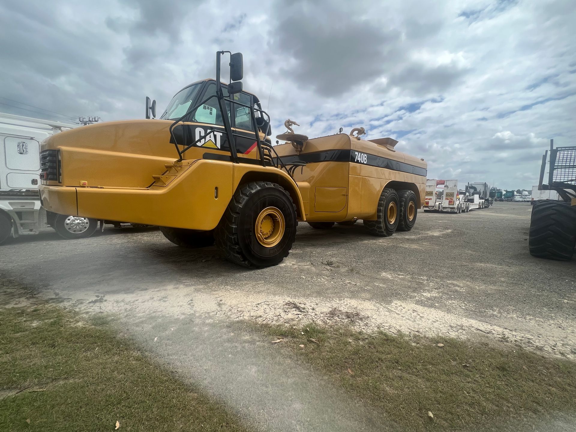 A large yellow dump truck is parked in a parking lot.