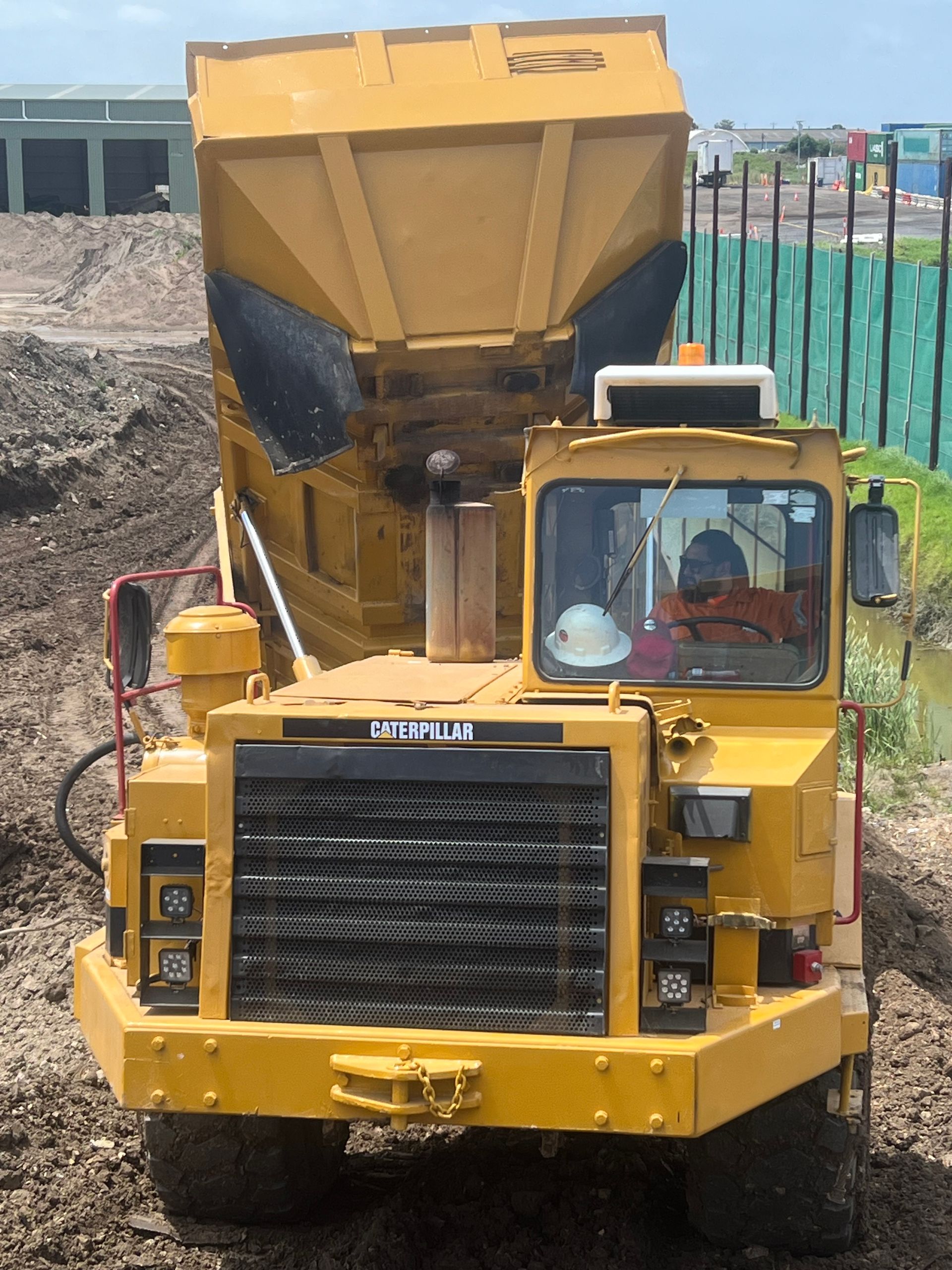 A yellow dump truck with the word caterpillar on the front