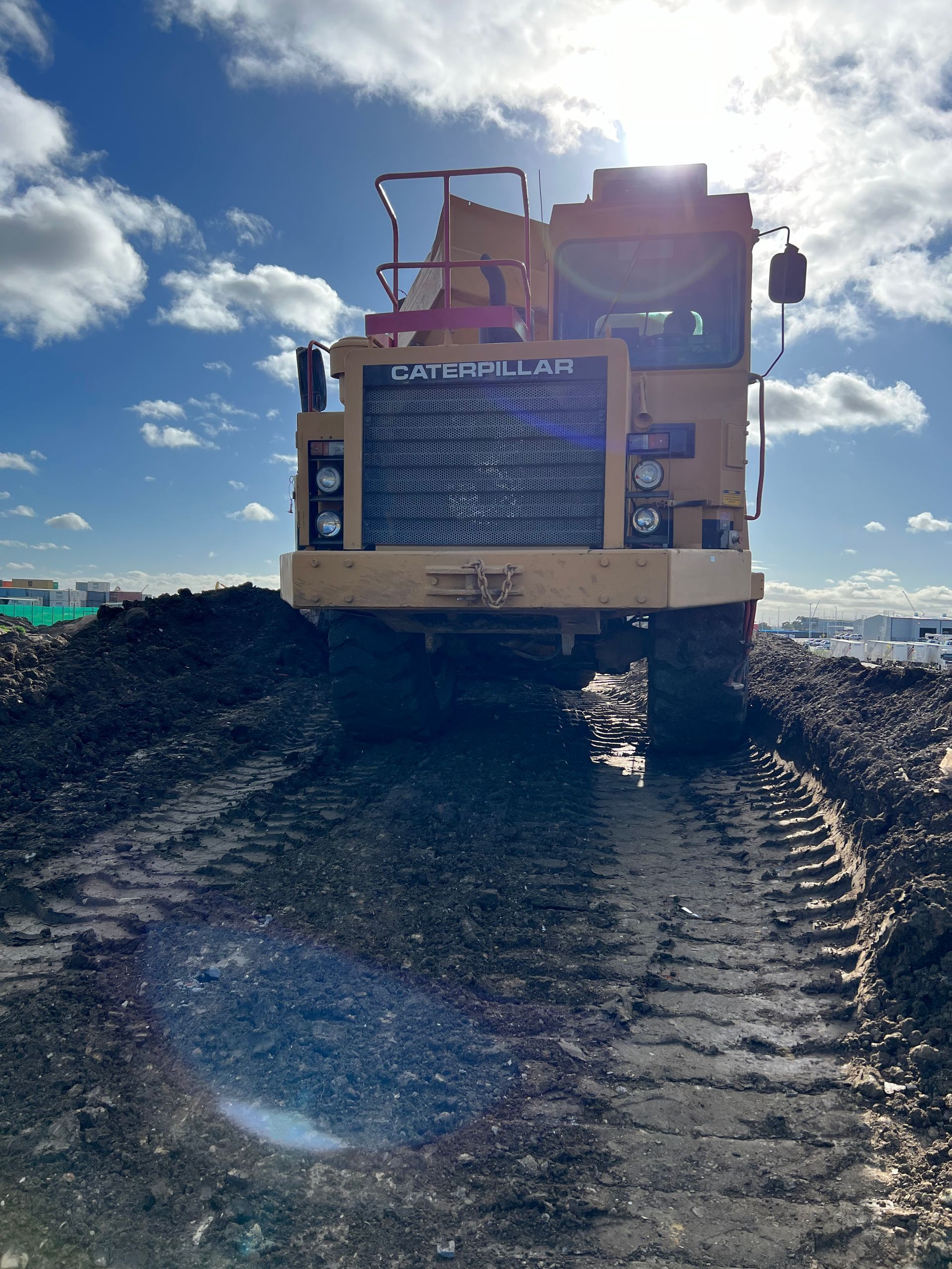 A bulldozer is driving down a dirt road.
