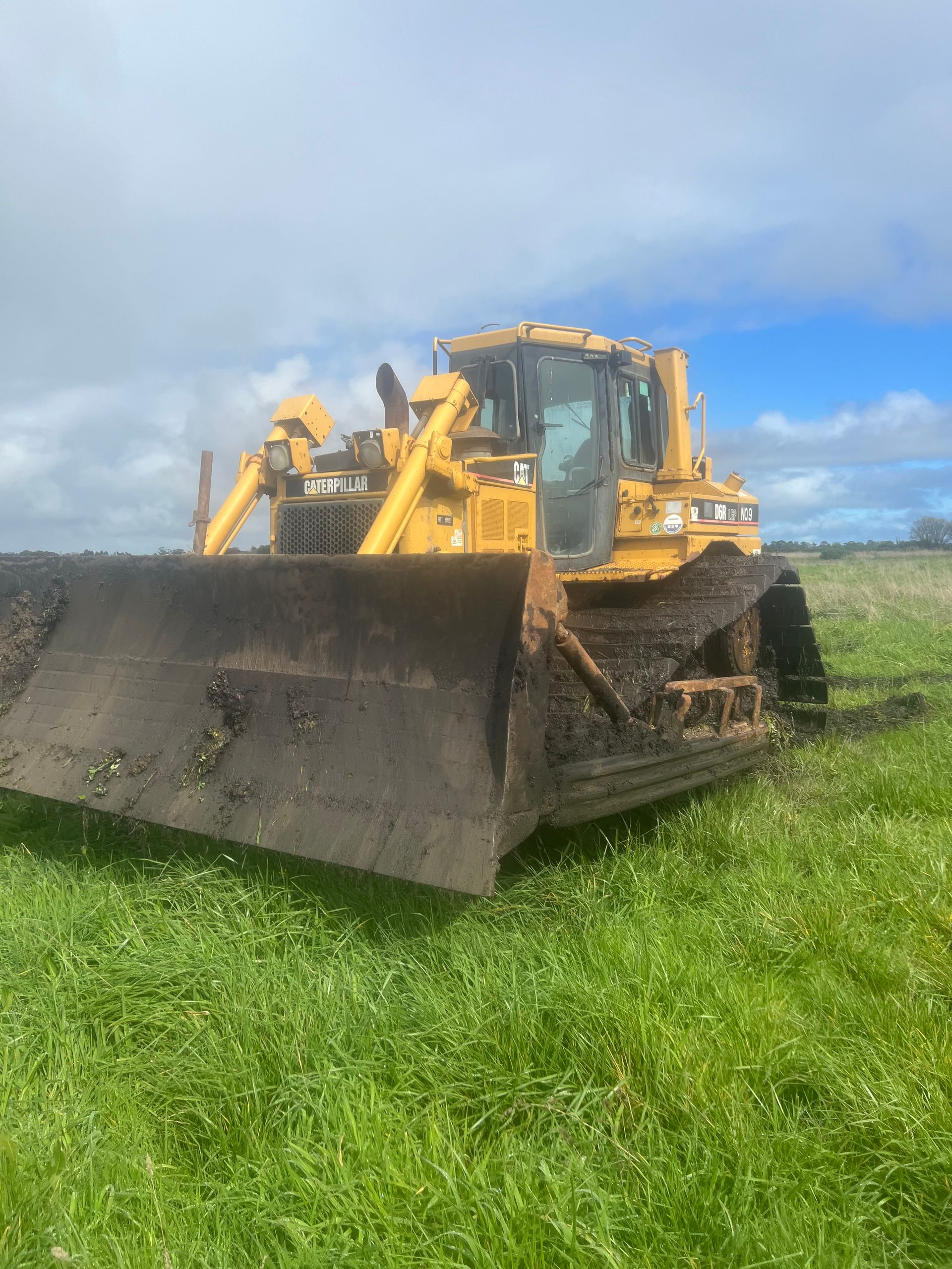 A bulldozer is parked in a grassy field.