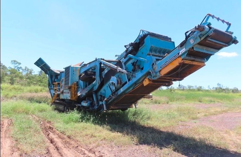 A large orange excavator is digging a hole in the dirt.
