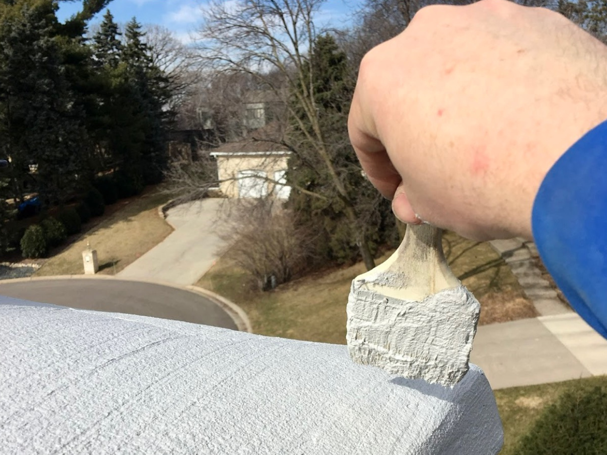 A person is painting a wall with a brush