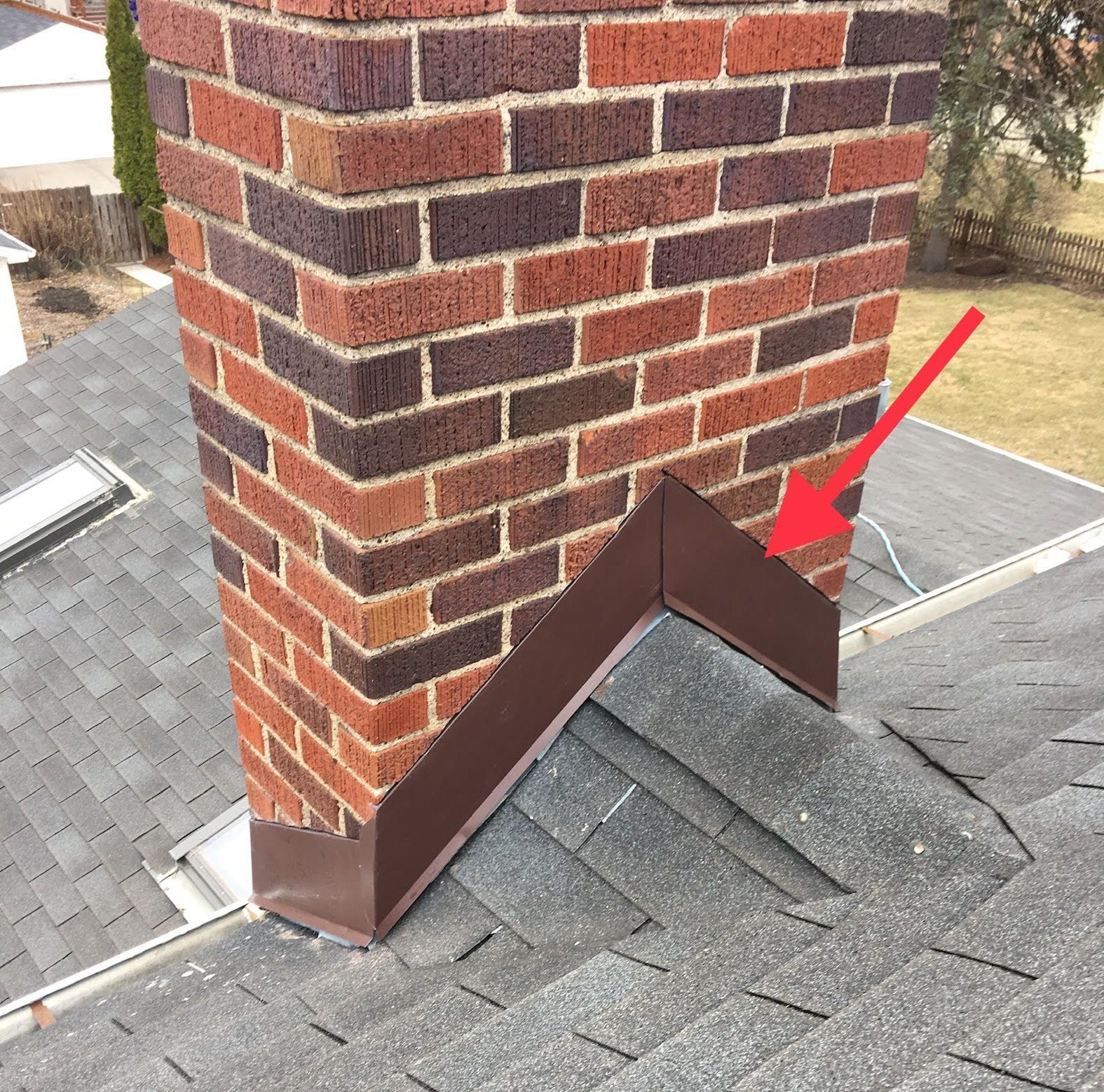 A red arrow points to a brick chimney on a roof