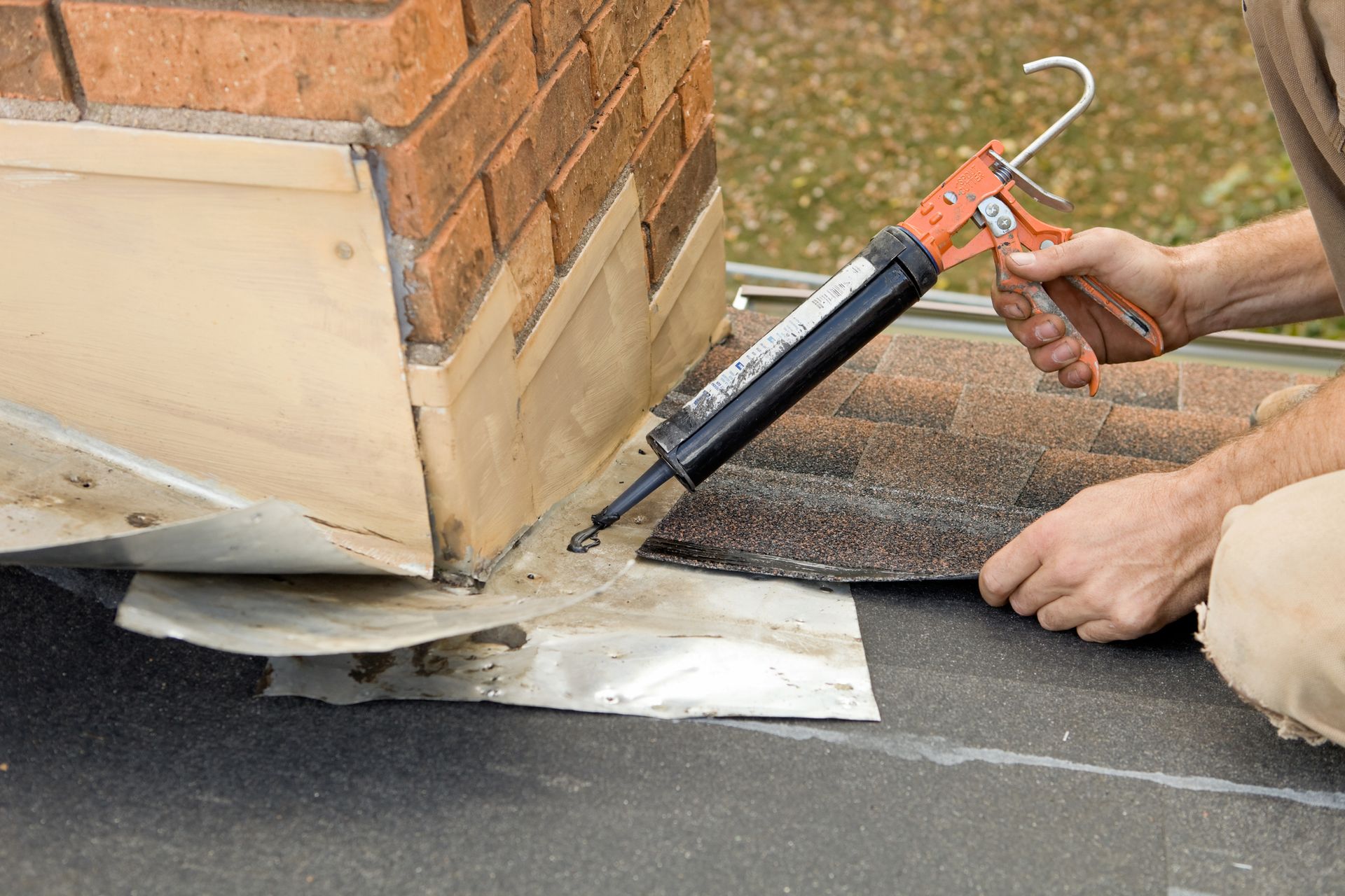 guardian chimney solutions technician applying caulk to chimney.