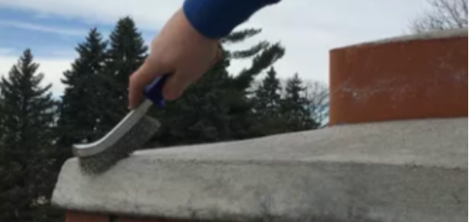 A person is cleaning a chimney with a brush.