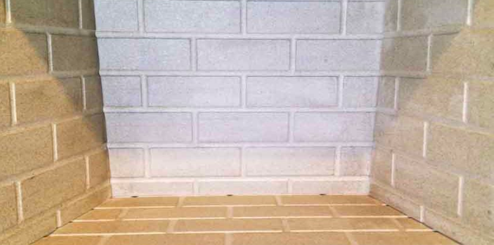 A brick fireplace with a tiled floor and a brick wall.