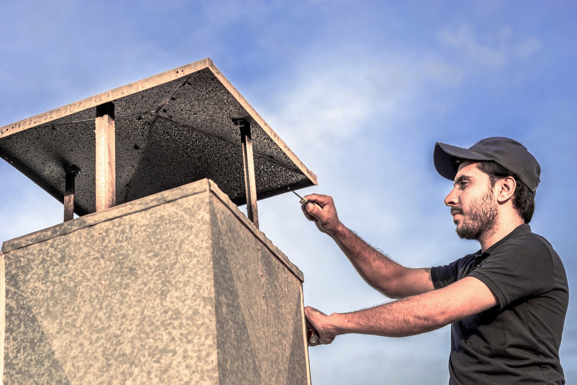Guardian Chimney technician applying waterproof sealant to a chimney in St. Louis Park.
