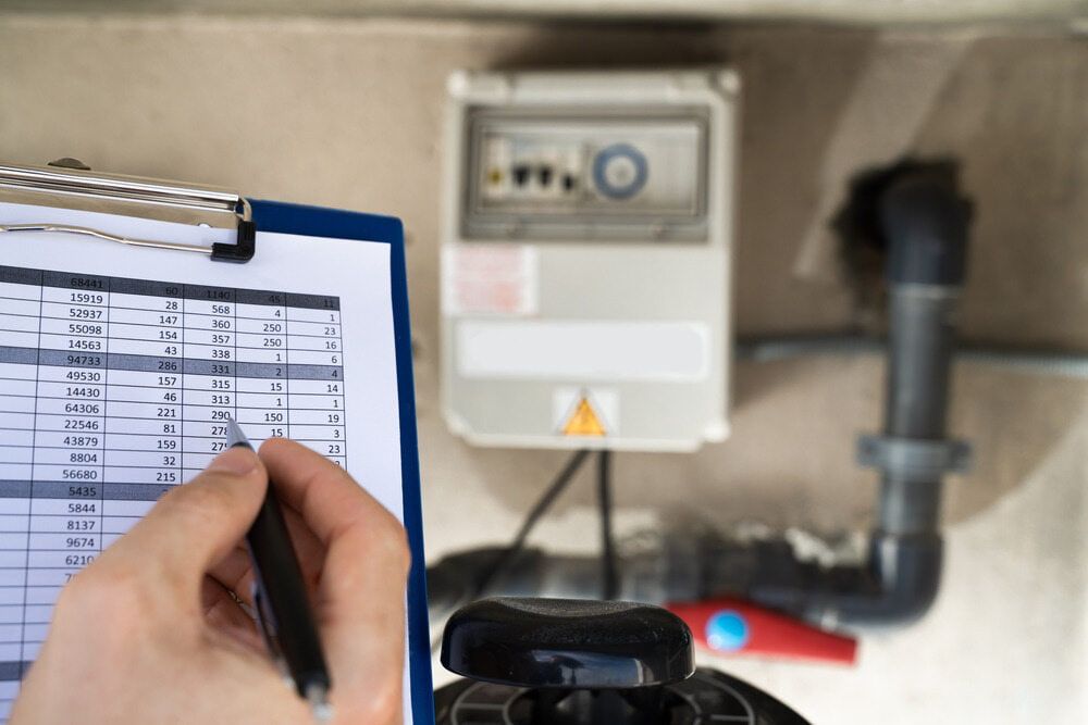 A Person is Writing on a Clipboard With a Pen — Reed Plumbing Industries in Mackay, QLD