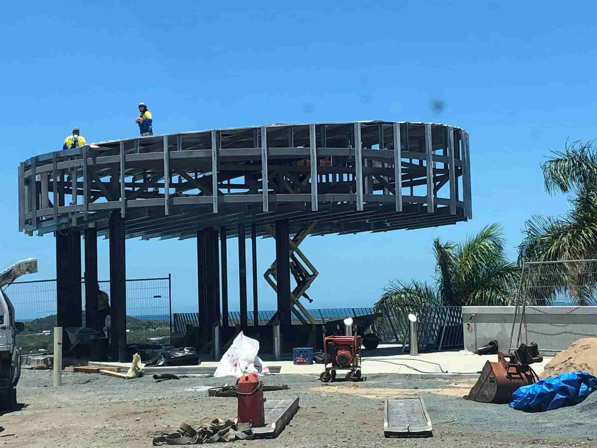 A Large Metal Structure is Being Built on Top of a Dirt Field — Reed Plumbing Industries in Mackay, QLD