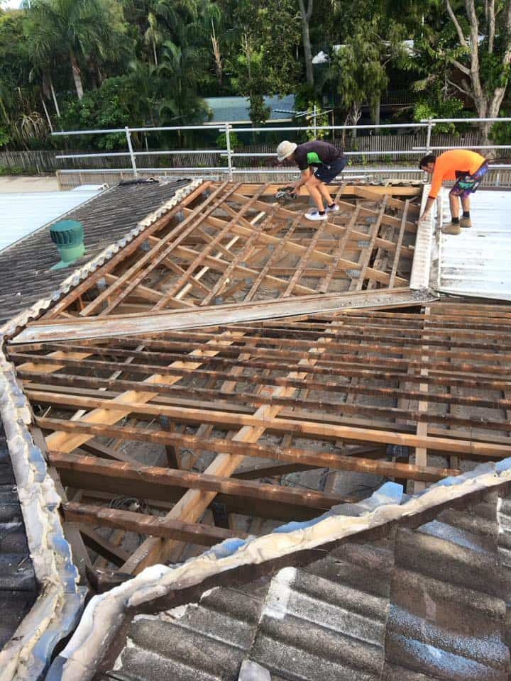 Two Men Are Working on the Roof of a Building — Reed Plumbing Industries in Mackay, QLD