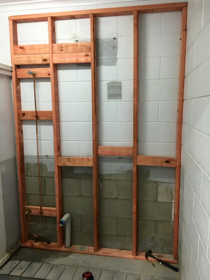 A Wooden Frame is Being Built on a Wall in a Bathroom — Reed Plumbing Industries in Mackay, QLD
