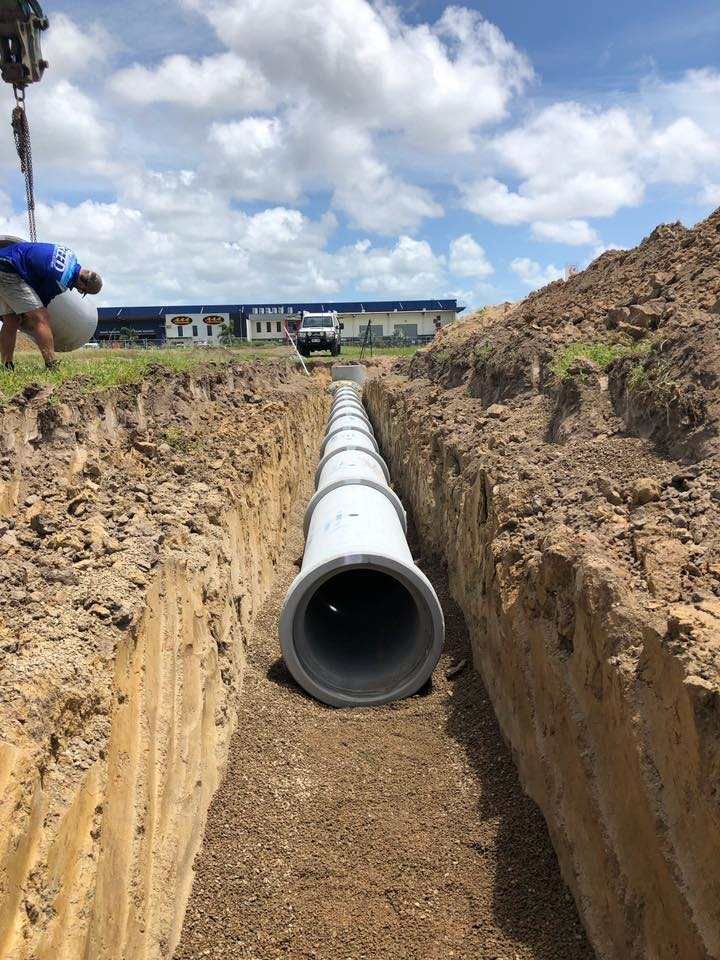 A Large Pipe is Being Installed in a Trench — Reed Plumbing Industries in Mackay, QLD