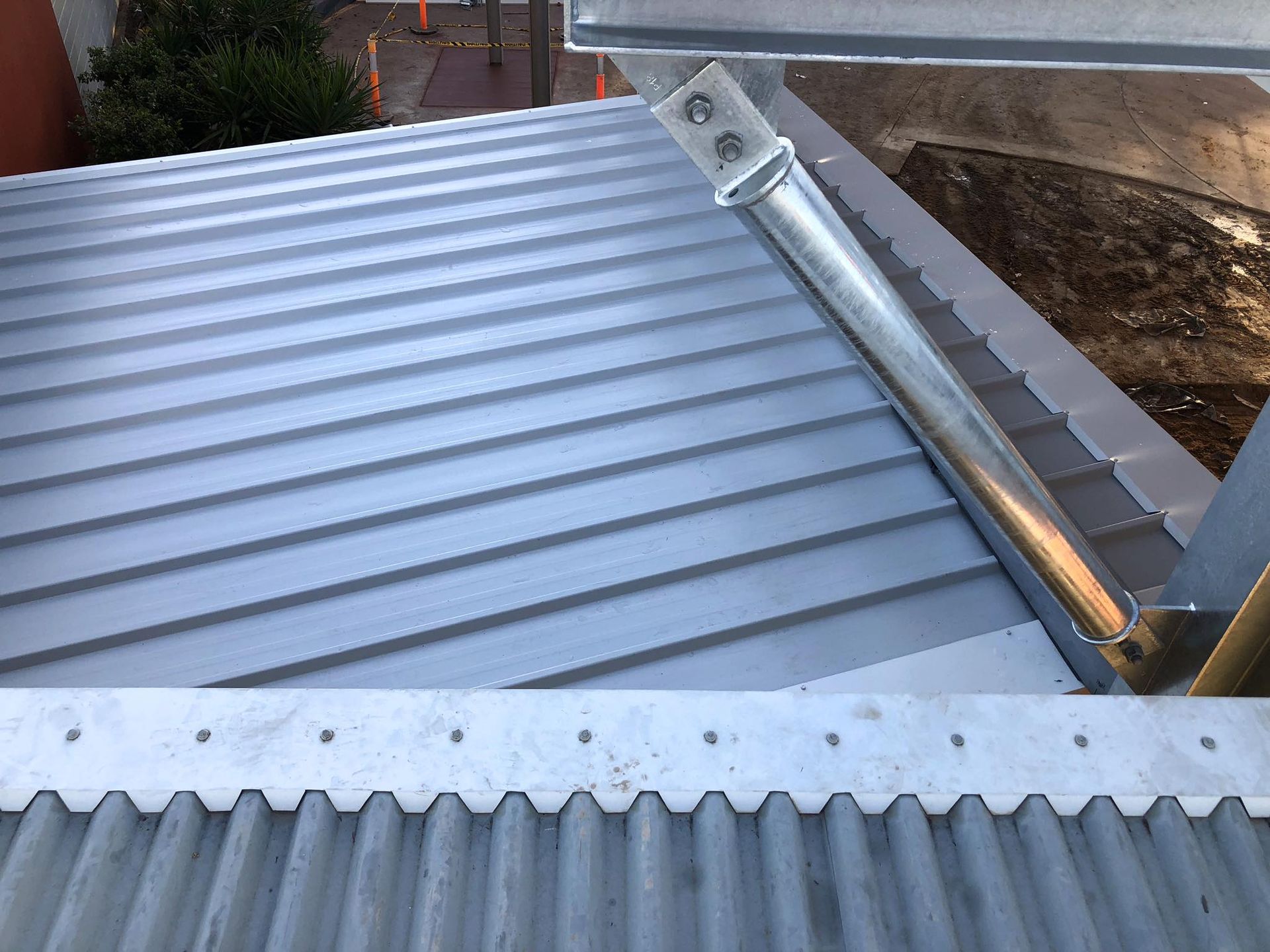 A close up of a metal roof with a metal pipe on it — Reed Plumbing Industries in Mackay, QLD