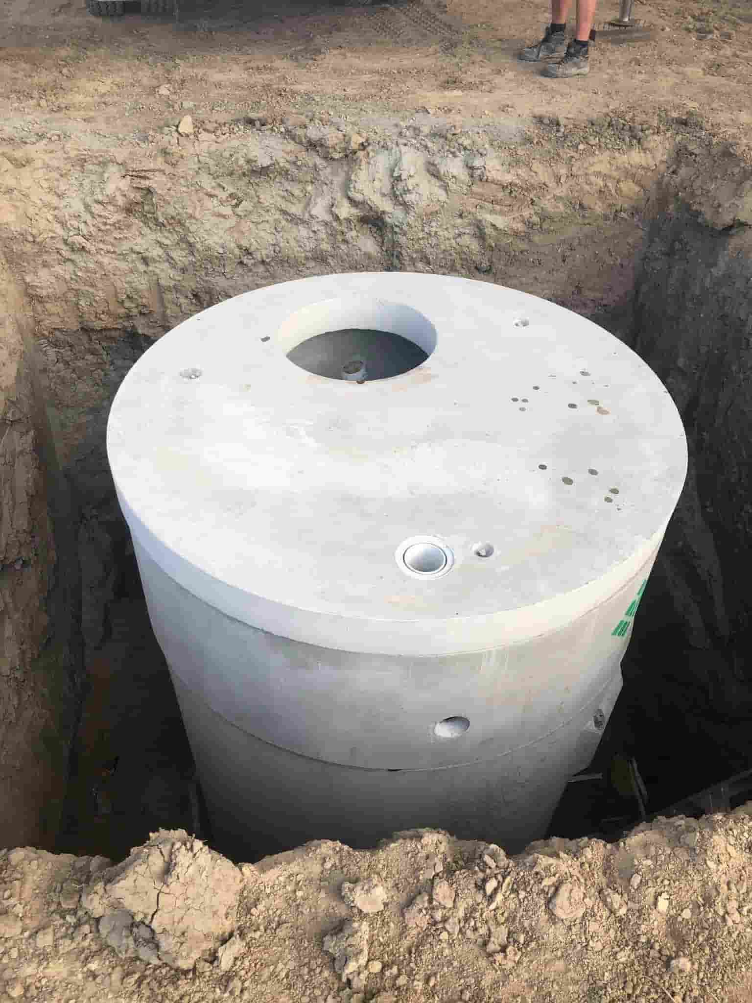 A Concrete Septic Tank is Sitting in a Hole in the Ground — Reed Plumbing Industries in Mackay, QLD