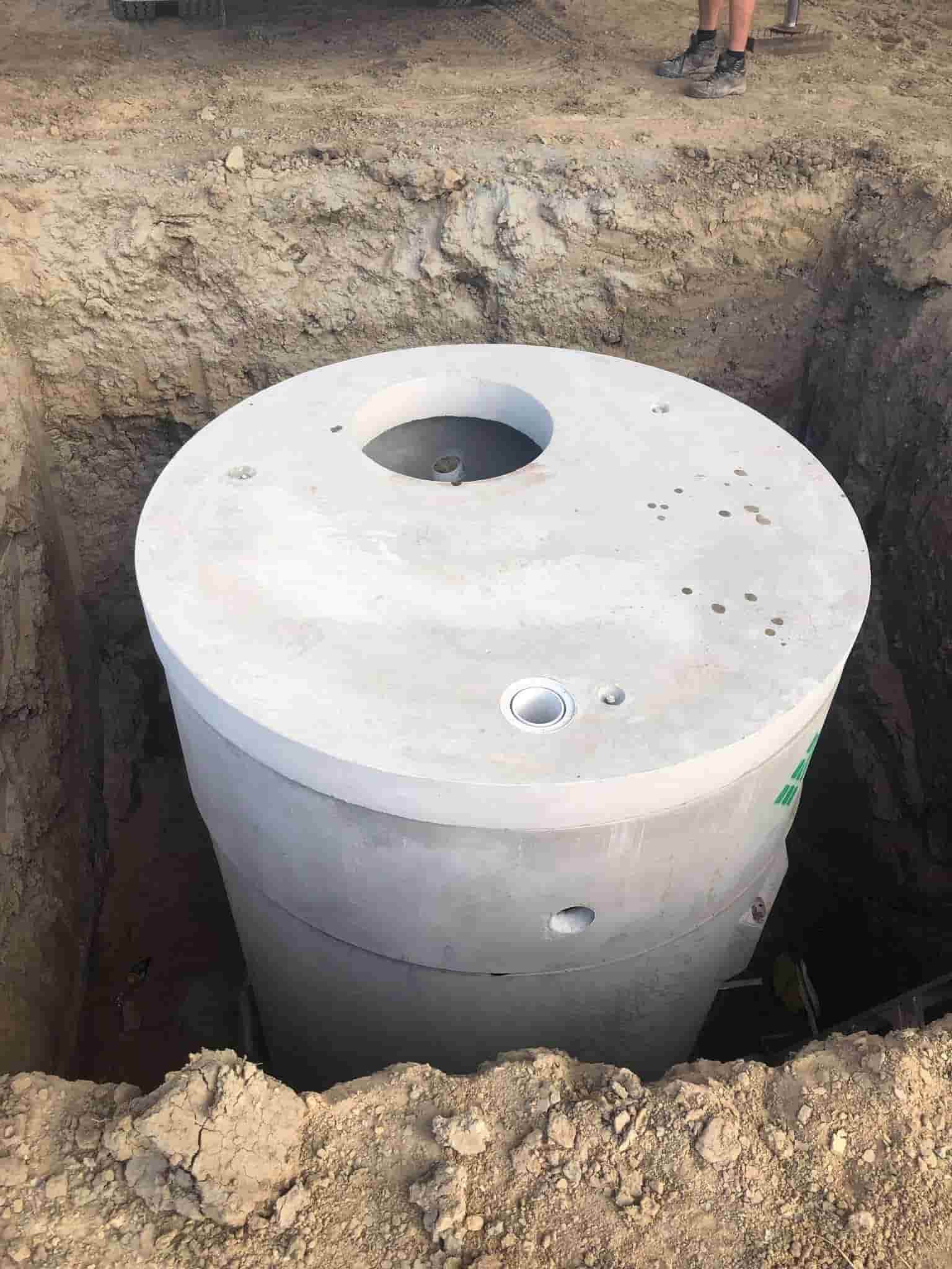 A Large Concrete Septic Tank is Sitting in a Hole in the Ground — Reed Plumbing Industries in Rural View, QLD