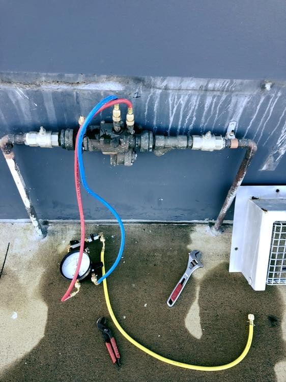 A Wrench is Laying on the Ground Next to a Hose — Reed Plumbing Industries in Rural View, QLD