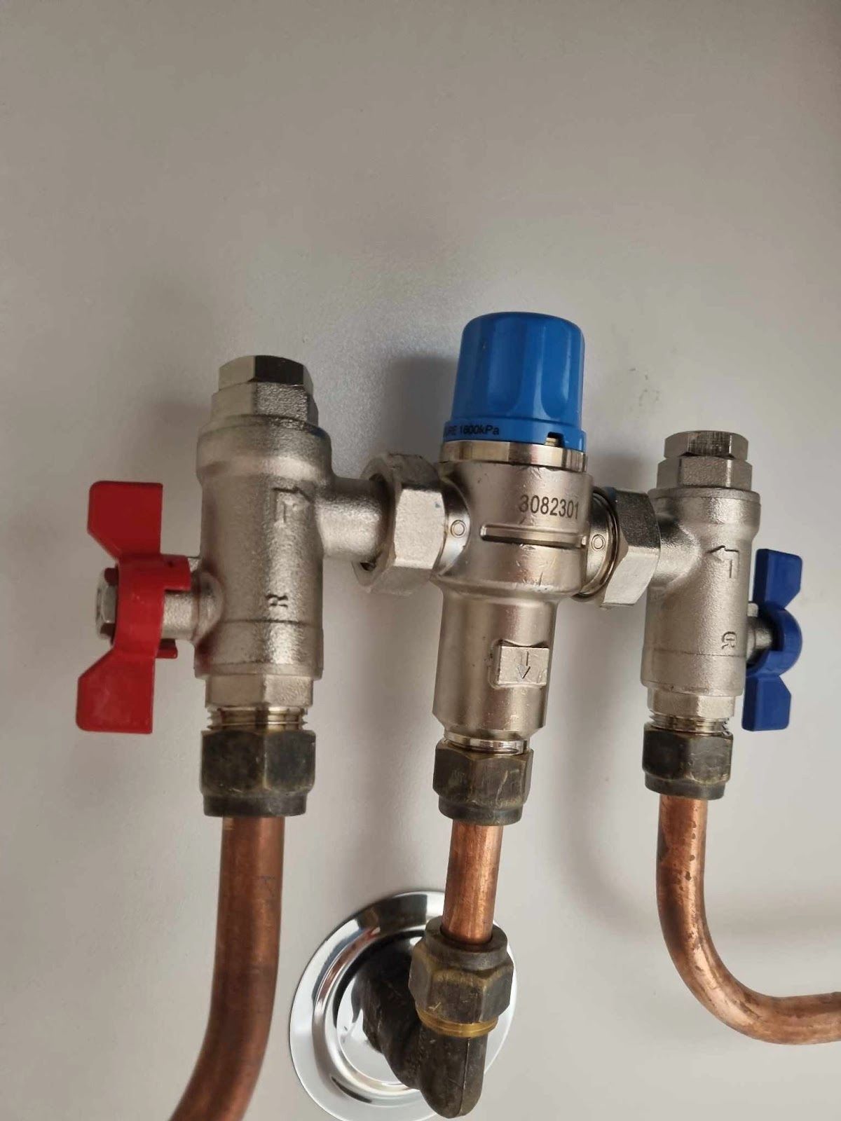 A Bunch of Pipes Are Connected to a Wall — Reed Plumbing Industries in Mackay, QLD