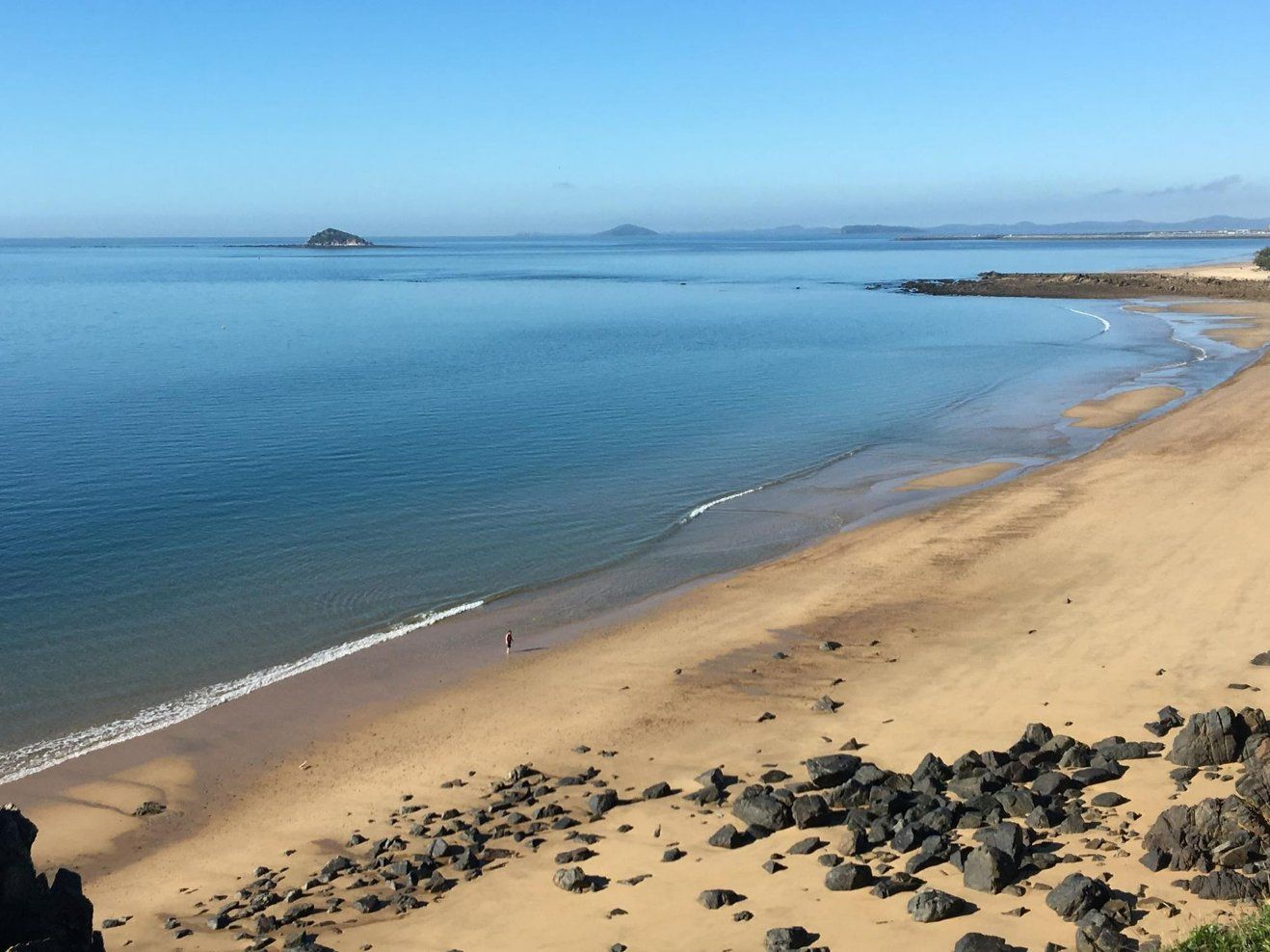 A Beach With a Large Body of Water in the Background — Reed Plumbing Industries in Eimeo, QLD