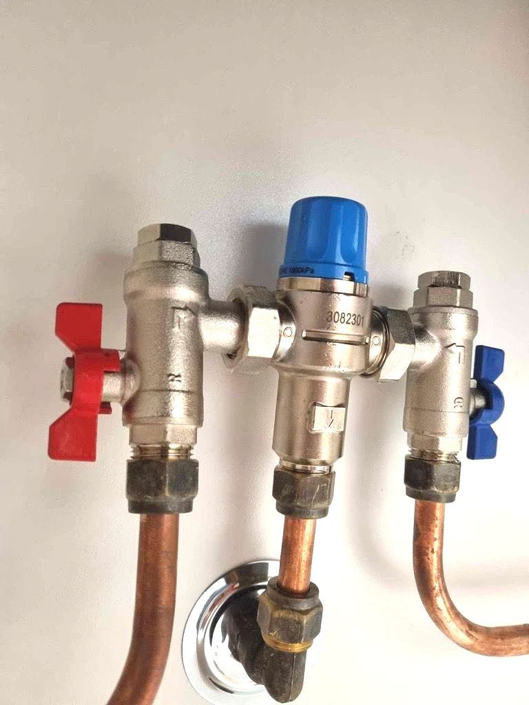 A close up of a copper pipe with valves attached to it — Reed Plumbing Industries in Mackay, QLD