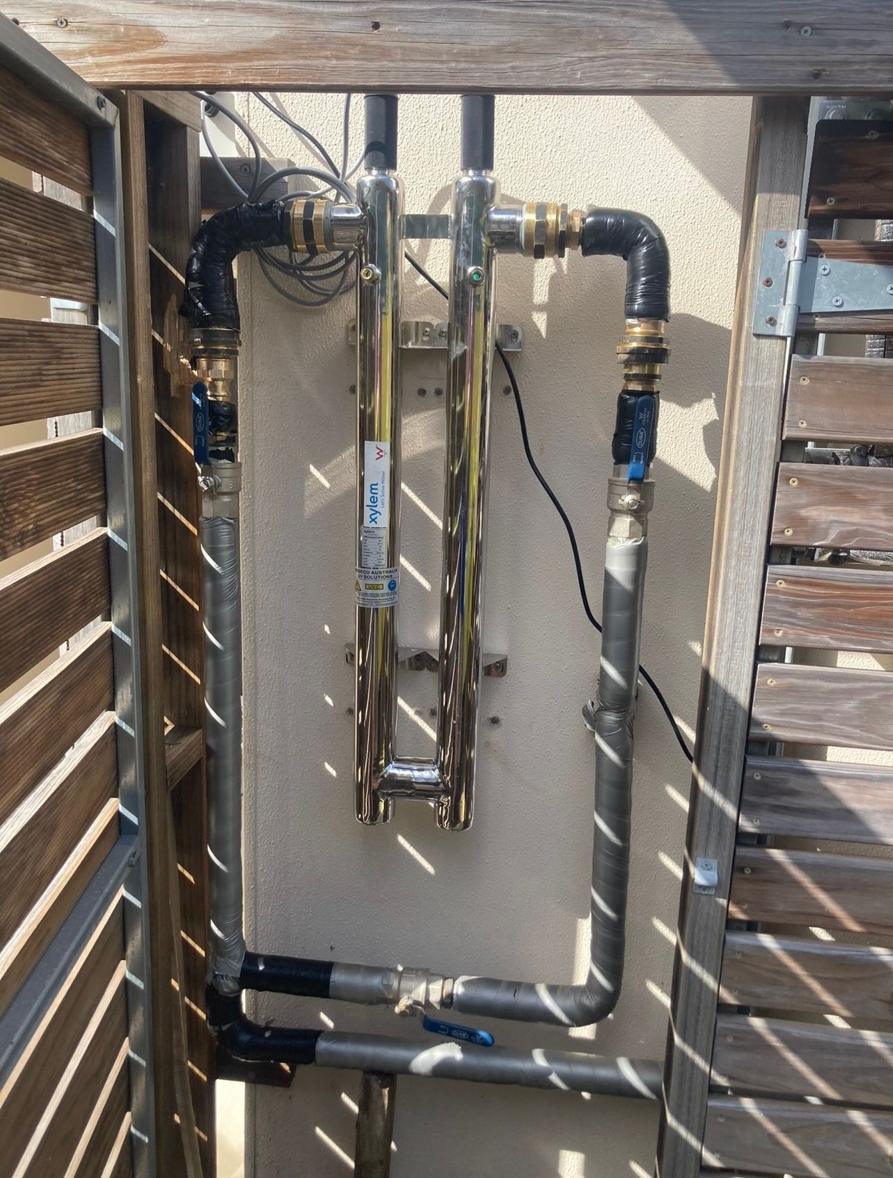 A Stainless Steel Sink With a Shower Head Attached to It in a Bathroom — Reed Plumbing Industries in Mackay, QLD