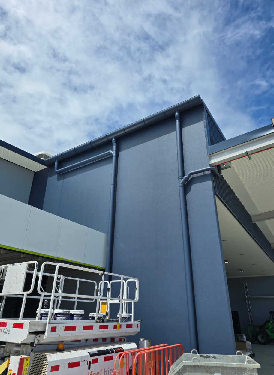 A Man is Working on a Roof With a Hammer — Reed Plumbing Industries in Mackay, QLD