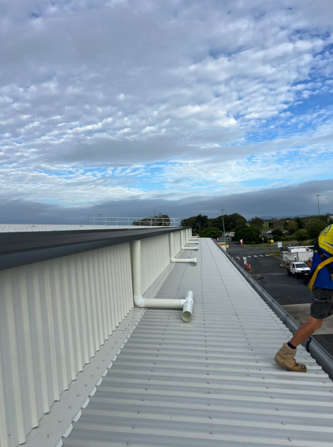 A White Roof With a View of a City and a Palm Tree — Reed Plumbing Industries in Mackay, QLD