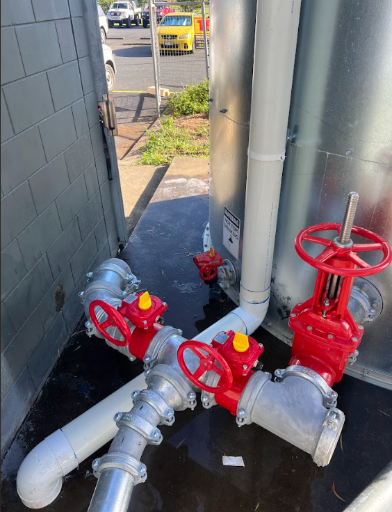 A Water Meter is Sitting on the Grass Next to a Pipe  — Reed Plumbing Industries in Mackay, QLD