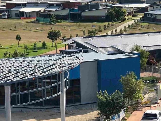 An Aerial View of a Building Under Construction With Solar Panels on the Roof — Reed Plumbing Industries in Mackay, QLD
