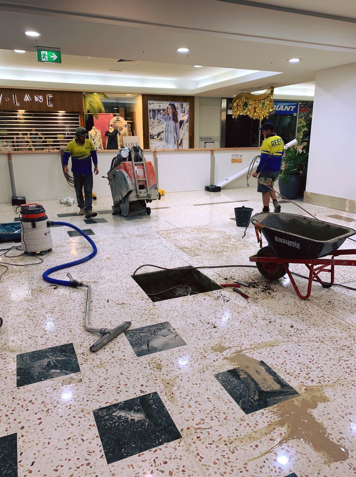 Work Men Doing Commercial Plumbing Work Inside A Shopping Centre — Reed Plumbing Industries in Mackay QLD