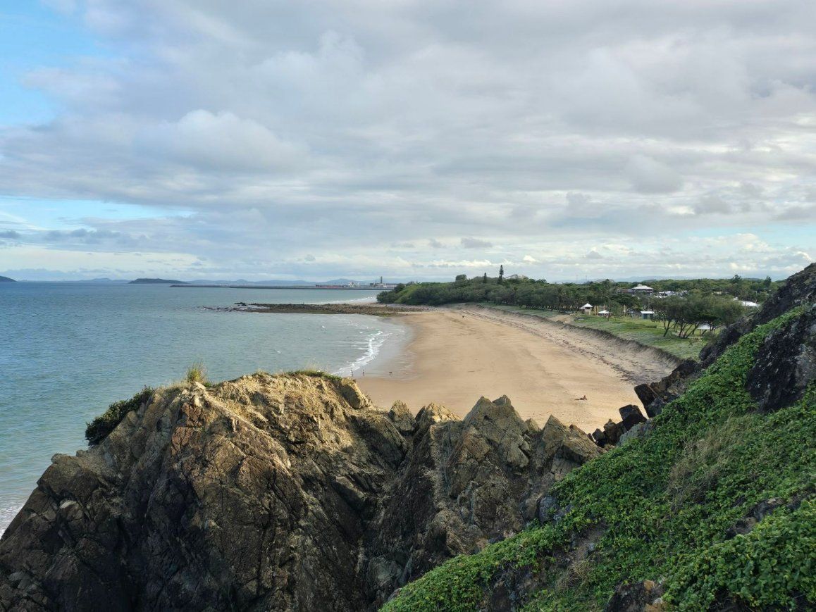 A View of a Beach From a Cliff Overlooking the Ocean — Reed Plumbing Industries in Slade Point, QLD