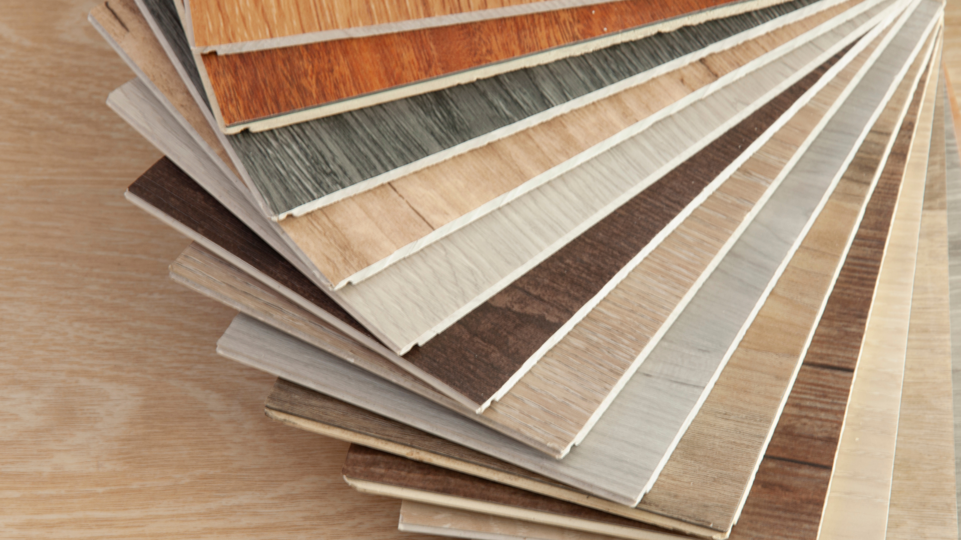 Samples of various wood-look flooring arranged in a fan shape, showcasing different colors and textures.