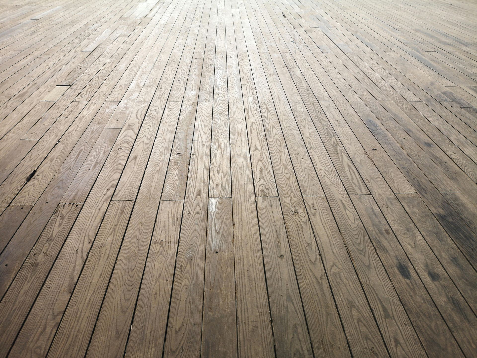 Empty weathered wooden floorboards with light shining from the top