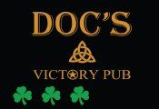 The logo for doc 's victory pub has three shamrocks on it.